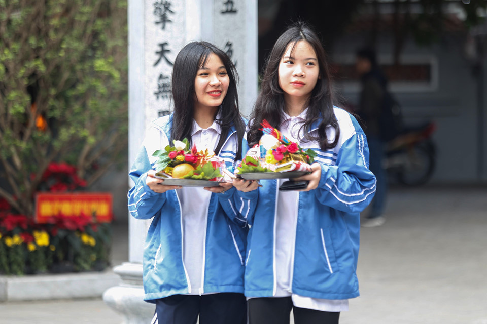 Nhiều em học sinh trong chiếc áo đồng phục cũng háo hức sắp lễ đi chùa.