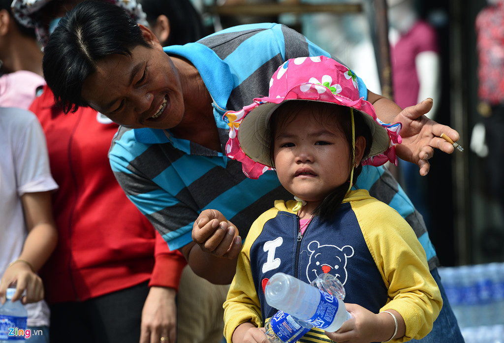 Bé Kỳ An, con gái nhỏ tuổi nhất của anh Khanh, bật khóc nức nở khi bị các anh chị lớn hơn "tranh" mất khách phát của mình khiến bố phải dỗ dành kiếm người cho bé đưa. "Đây là năm đầu tiên tôi phát động gia đình tham gia phát nước miễn phí cho khách đi chùa. Tuy điều kiện gia đình không giàu có, số tiền mua nước cũng không nhiều nhưng mọi người vui, vừa giáo dục cho con cháu về tinh thần chia sẻ với cộng đồng", anh Khanh chia sẻ.