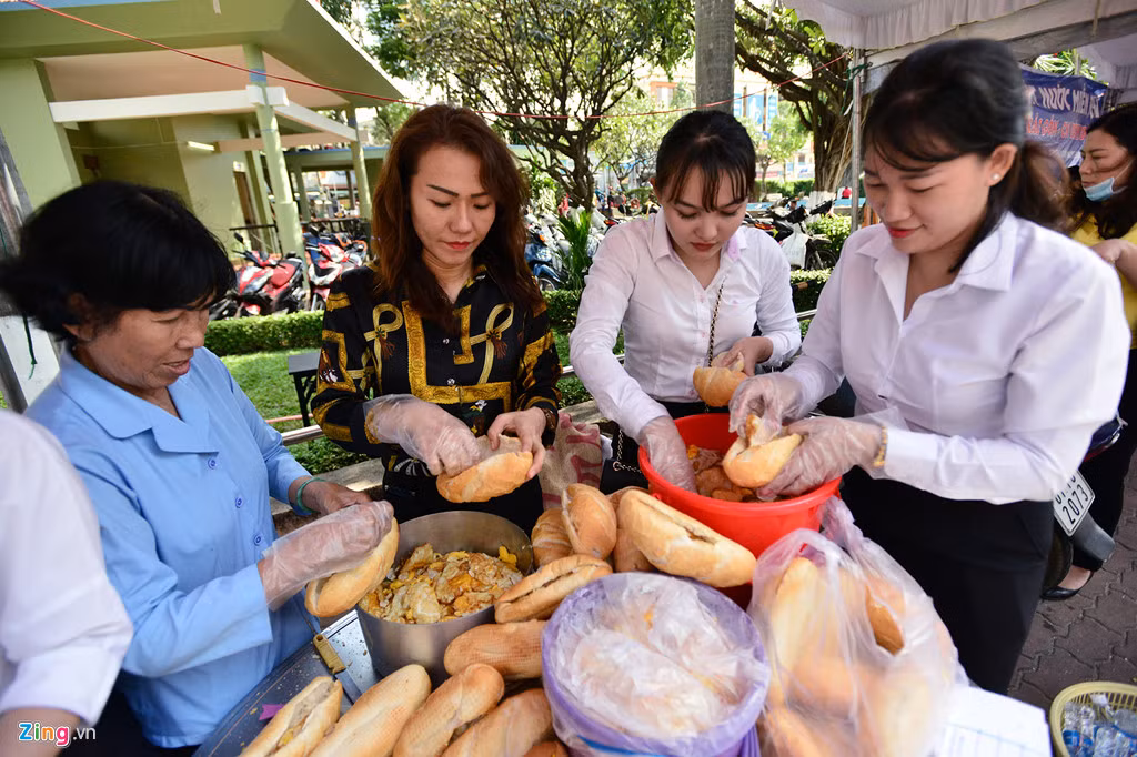 Các nhóm nhân viên văn phòng các công ty trên địa bàn cũng tham gia. Trong ảnh, các nhân viên của một chi nhánh ngân hàng không ngớt tay làm những ổ bánh mì ốp la với những nồi, xô trứng liên tục được mang tới.