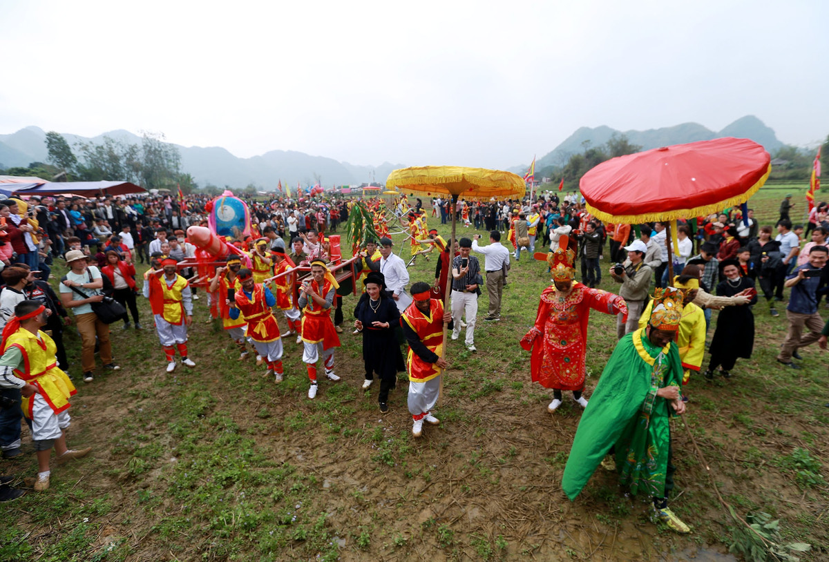 Đoàn "rước của quí khổng lồ" băng qua ruộng để tới miếu.