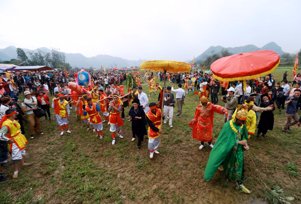 Đoàn "rước của quí khổng lồ" băng qua ruộng để tới miếu.