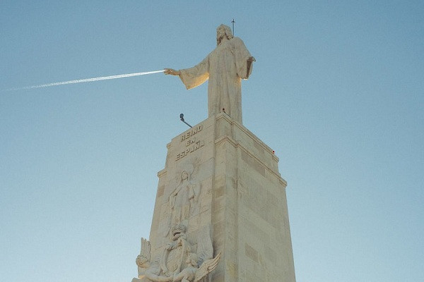 Bức hình vô tình bắt trúng khoảnh khắc trùng hợp khó tin khi chiếc máy bay bay ngang qua bầu trời, đúng tầm tay của bức tượng.