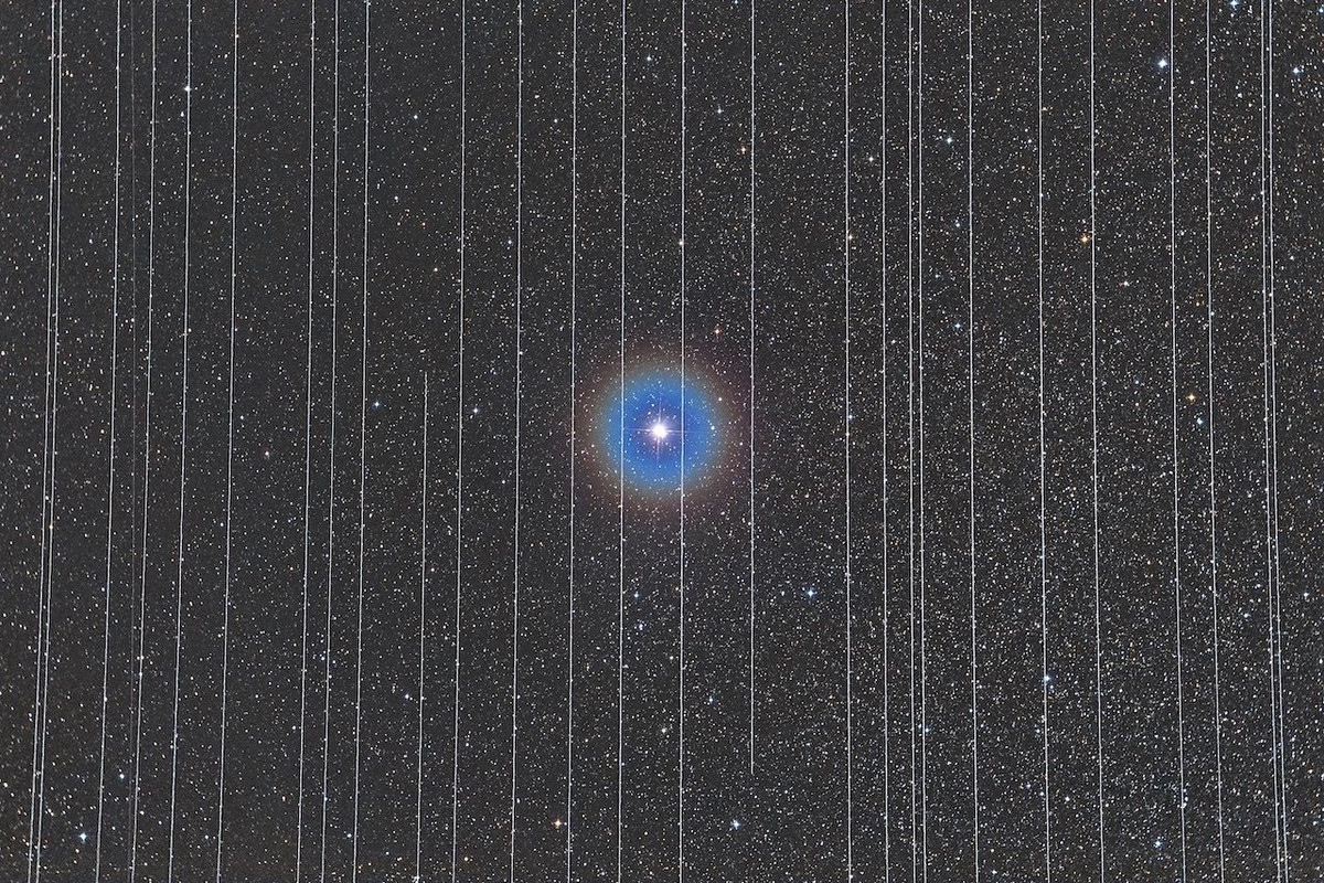 Ngôi sao ở trung tâm bức ảnh là sao đôi Albireo, được bao quanh bởi các vệt của các vệ tinh chuyển động.