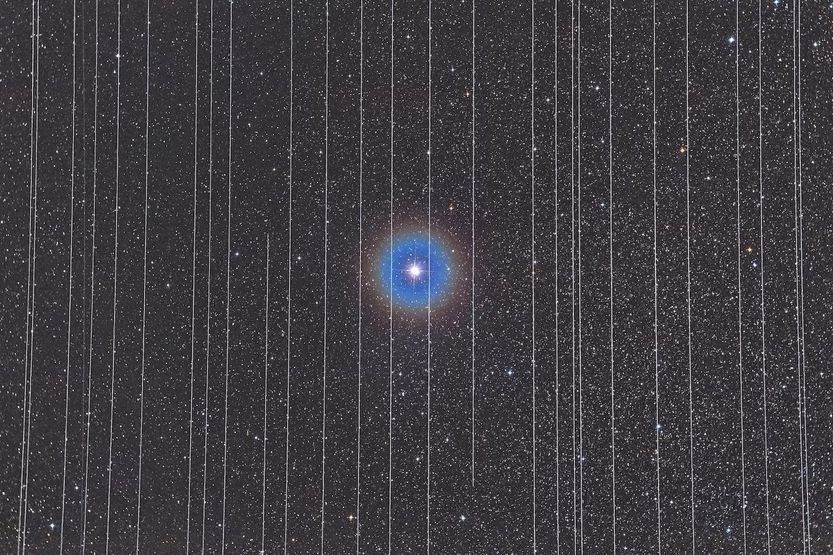 Ngôi sao ở trung tâm bức ảnh là sao đôi Albireo, được bao quanh bởi các vệt của các vệ tinh chuyển động.