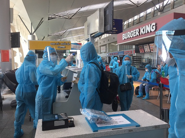 Hành khách mắc kẹt tại Đà Nẵng nghiêm túc thực hiện đo thân nhiệt và kiểm tra sức khỏe trước khi làm thủ tục bay và lên máy bay trở về Hà Nội.