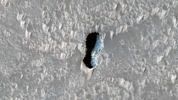 Miệng hố khác trông giống như hạt đậu được MRO chụp ở phía nam núi lửa Arsia Mons. Những bức ảnh chụp miệng hố bí ẩn trên sao Hỏa này sẽ được NASA phân tích để tìm ra nguồn gốc.