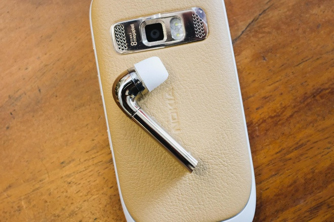 Tai nghe J chỉ có duy nhất một bên được sạc thông qua một dock có kẹp để gài vào túi quần, cổ áo.