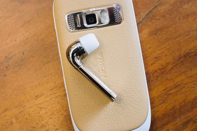 Tai nghe J chỉ có duy nhất một bên được sạc thông qua một dock có kẹp để gài vào túi quần, cổ áo.