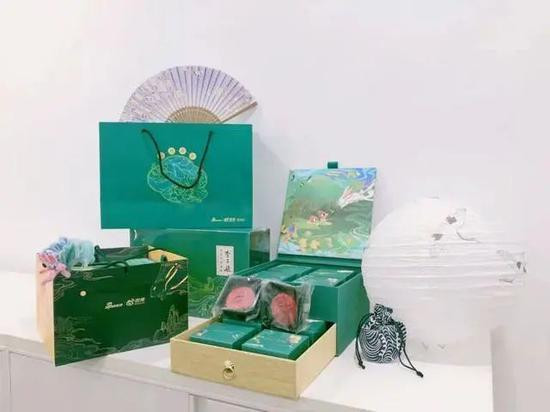 Hộp quà dịp Trung thu của tập đoàn Sina có màu xanh lá cây đậm, là loại hộp kéo hai lớp, đi kèm hai mặt búp bê đặc trưng và thiệp chúc mừng.