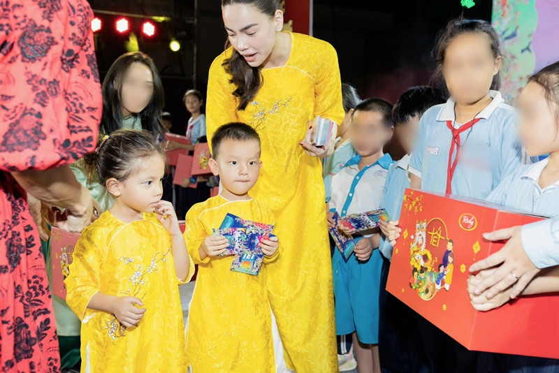 Hồ Ngọc Hà cùng cặp song sinh diện áo dài khi tặng quà cho các em nhỏ.