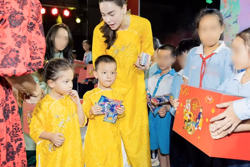 Hồ Ngọc Hà cùng cặp song sinh diện áo dài khi tặng quà cho các em nhỏ.