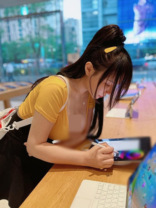 Cúi người sử dụng máy tính bảng khi đi mua sắm, Janie để lộ vòng một quyến rũ.