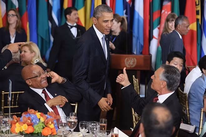 Tổng thống Mỹ Barack Obama chào các lãnh đạo và đại sứ trong tiệc trưa do Tổng thư ký Liên Hợp Quốc Ban Ki Moon tổ chức ở New York ngày 28/9. Trong khi đó, Tổng thống Nam Phi Jacob Zuma vẫn bận rộn trả lời điện thoại. Tiệc trưa diễn ra giữa ngày họp của Đại hội đồng Liên Hợp Quốc lần thứ 70.
