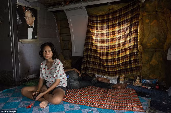 Một cô gái ngồi trong chiếc máy bay và nhìn xa xăm.