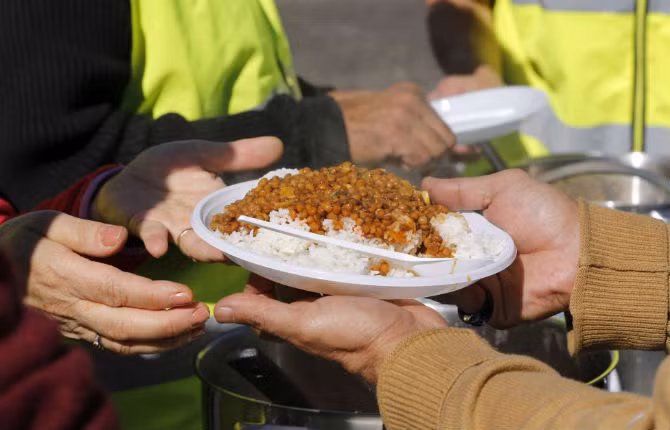 Người tị nạn nhận xuất cơm miễn phí từ tổ chức cứu trợ tại khu trại New Jungle ở thành phố Calais, Pháp ngày 20/9.