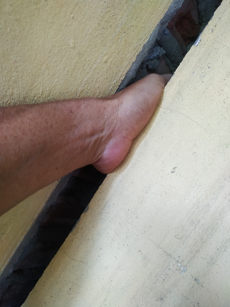 Vết nứt toác chạy dài trên tường nhà gia đình ông Hải để lọt cả bàn tay người lớn. Ngôi nhà này cũng có hiện tượng bị sụt lún, nghiêng.