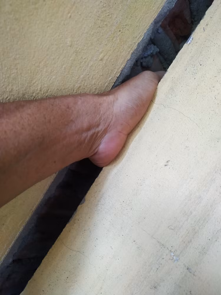 Vết nứt toác chạy dài trên tường nhà gia đình ông Hải để lọt cả bàn tay người lớn. Ngôi nhà này cũng có hiện tượng bị sụt lún, nghiêng.