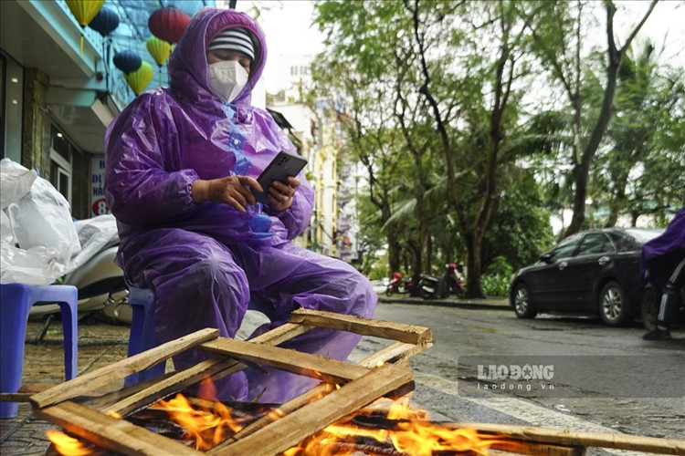 Nhiều người lao động đã đốt lửa sửa ấm để có thể chống chọi lại cái rét. (Ảnh: Lao Động).