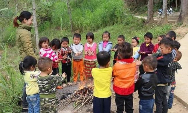 Cô và trò sưởi ấm sau tiết học ngoại khóa ngoài trời. (Ảnh: GVCC) 