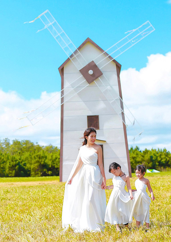 Minh Hà đưa hai con lên Đà Lạt chơi và xem ông xã làm phim. Ba mẹ con mặc trang phục kiểu nữ thần chụp ảnh với chiếc cối xay gió cao 14m mà vợ chồng cô đã dựng lên để quay phim 'Lật mặt: Nhà có khách'.