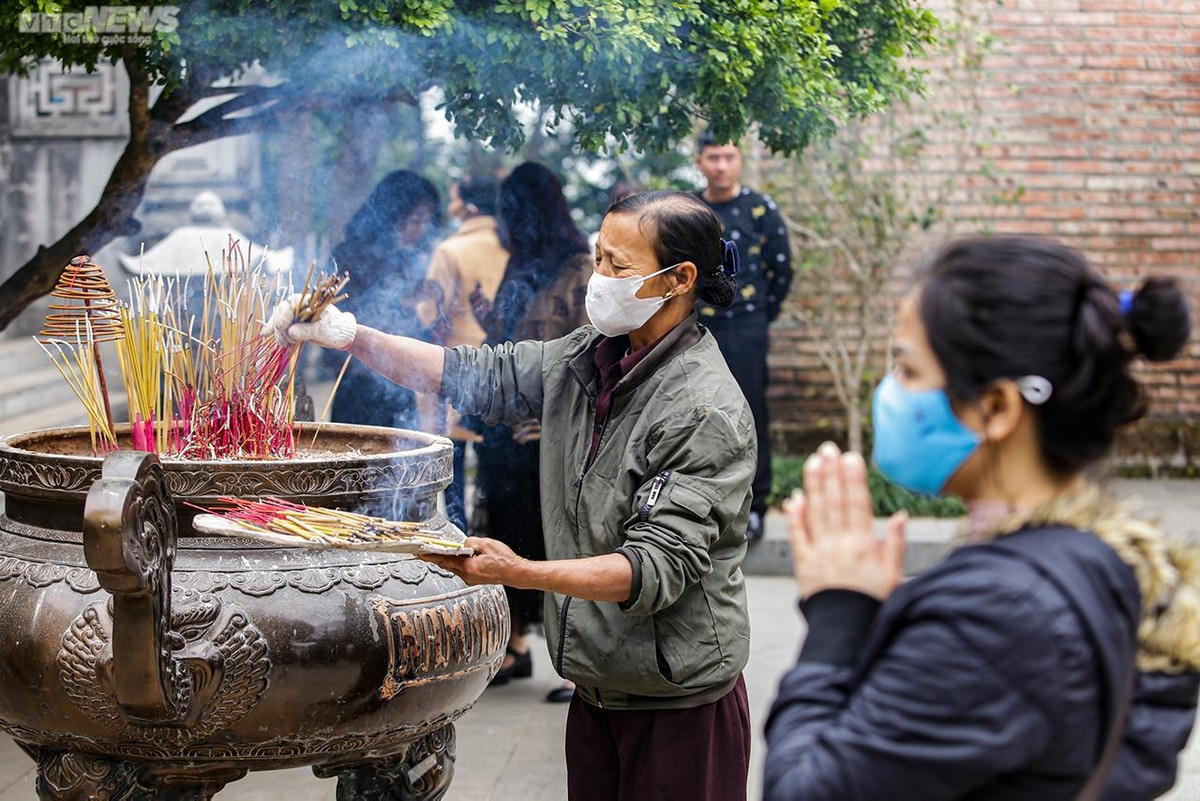 Do lượng người thắp hương quá đông, ban quản lý phải cử người rút bớt các nén hương ở lư hương.