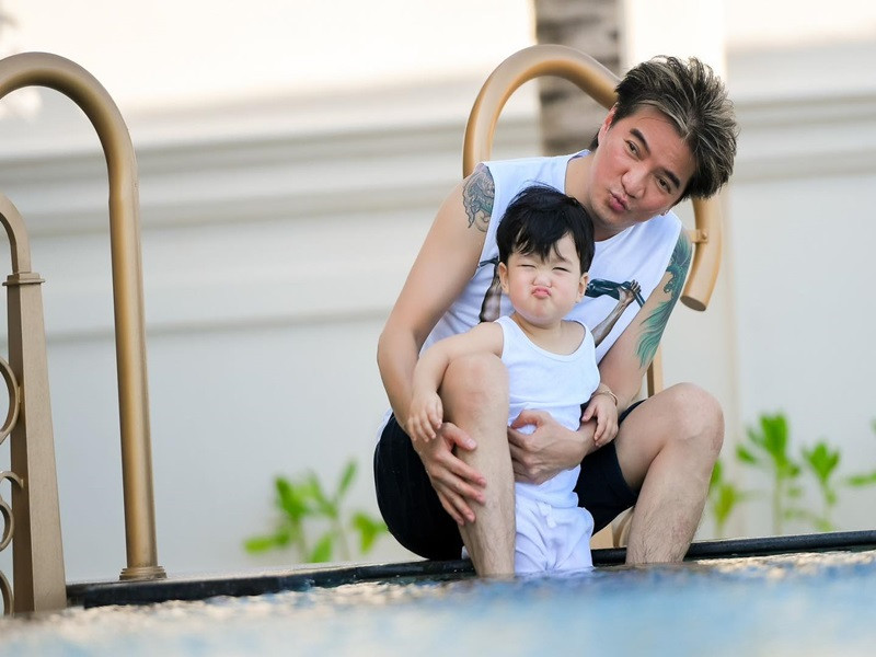 Cậu nhóc chu môi tạo dáng bên bố.