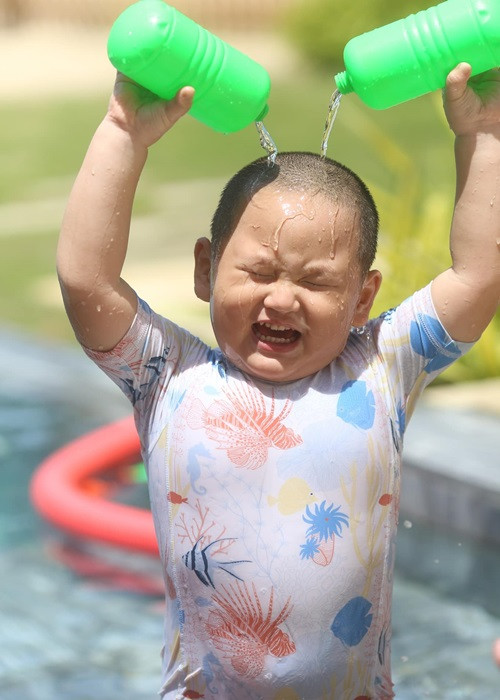 Khoảnh khắc con trai Trà My gây cười khi đổ nước vào đầu trong bể bơi.