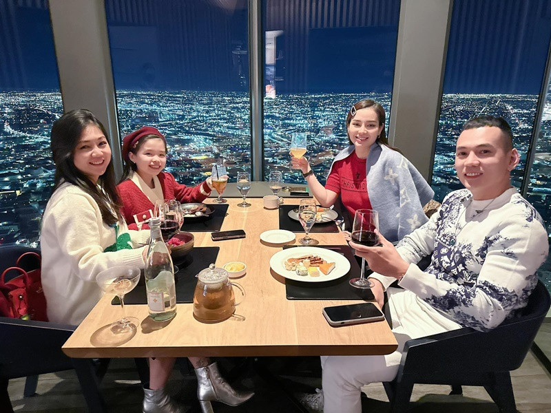 Vợ chồng Lý Bình cùng con gái ăn tối trên tòa nhà cao tầng.