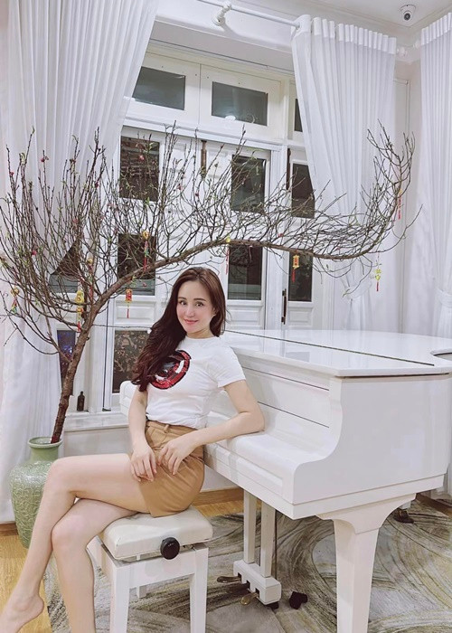 Nữ ca sĩ trưng hoa đào bên cây đàn piano.