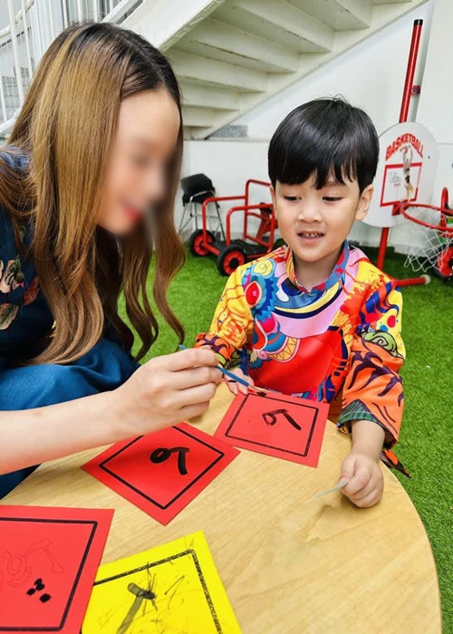 Con trai Đàm Vĩnh Hưng được tô màu bao lì xì con mèo, được cầm tay viết thư pháp, chơi các trò chơi dân gian.