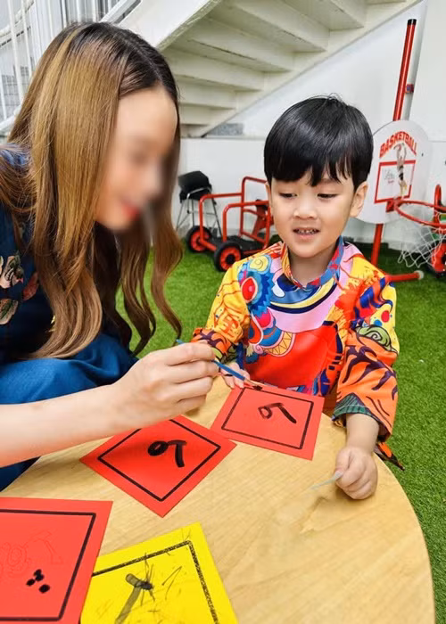 Con trai Đàm Vĩnh Hưng được tô màu bao lì xì con mèo, được cầm tay viết thư pháp, chơi các trò chơi dân gian.