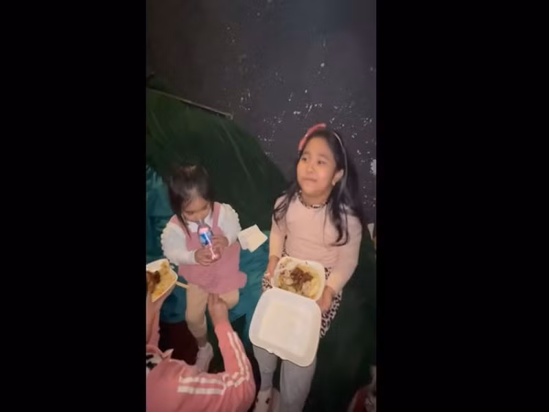 Trong lúc chờ bố diễn, hai cô con gái của Tự Long ăn cơm hộp.