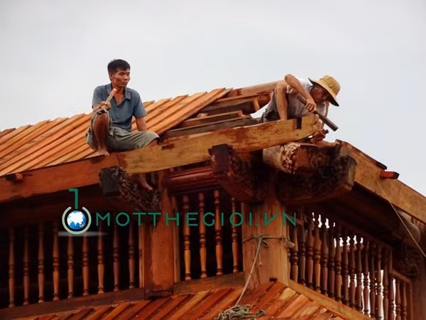 Những nghệ nhân này đang chế tác hoa văn một góc mái của ngôi nhà.