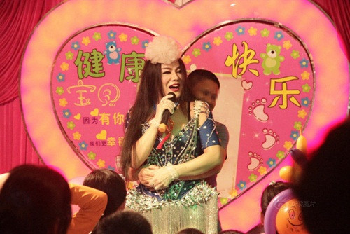 Không dừng ở đó, lễ 100 ngày kỳ quặc này có cả sự góp mặt của một ca sĩ chuyển giới người Thái Lan, ăn mặc hở hang, thực hiện những động tác vũ đạo khêu gợi, thậm chí còn tương tác với người xem cực kỳ thân mật, cho phép người xem ôm ấp, sờ soạng mình trên sân khấu. Ngoài ra, cha mẹ của em bé mời cả một nghệ sĩ diễn xiếc mạo hiểm đến buổi lễ, thực hiện một màn nuốt than đang cháy rất rùng rợn, khiến nhiều người khiếp sợ.