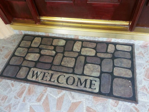 Trước cửa anh khéo léo thiết kế một tấm thảm có dòng chữ "Welcome" nghĩa là "Mời vào" để tạo sự hiếu khách.