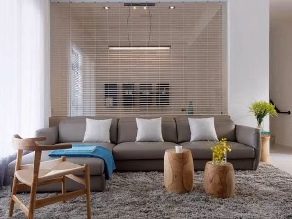 Bộ sofa màu ghi được đặt gần với cửa sổ,nơi ngập tràn ánh sáng tự nhiên, tạo điểm nhấn tinh tế cho không gian phòng khách.