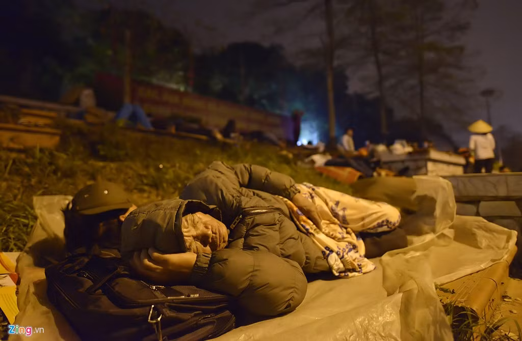 Có người mang theo áo mưa trải phía dưới các bồn hoa nằm ngủ.