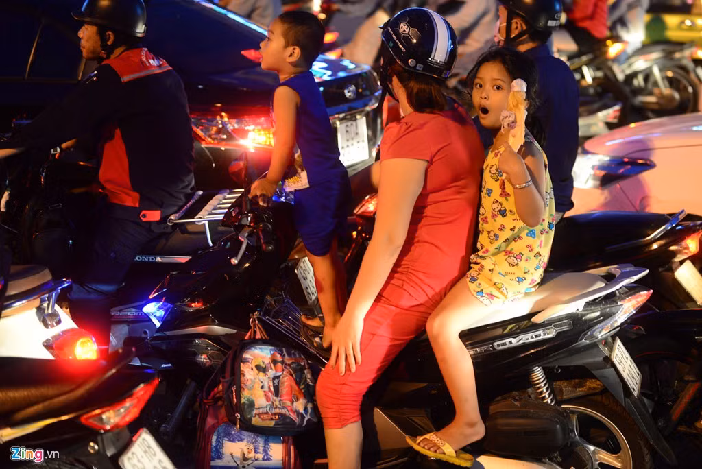 Những đứa trẻ cũng sốt ruột như người lớn. Chúng đã phải đứng cao lên xe để hóng phía trước.