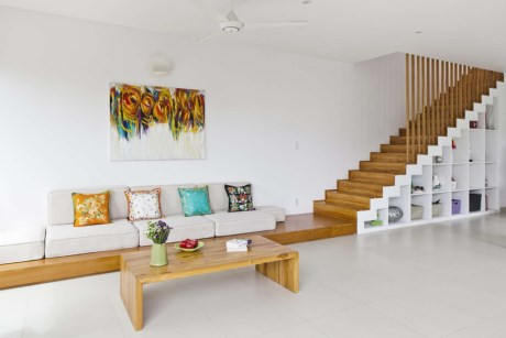 “D2 Town House” được xây dựng trên một lô đất góc 9.45m rộng, 18.9m sâu, với thiết kế sang trọng nhưng cũng vô cùng gần gũi với thiên nhiên. Phòng khách, bếp và khu vực ăn uống được bố trí ở tầng một. Nhờ phong cách thiết kế mở mà không gian này như được “cơi nới” hơn, tạo sự thoáng đãng và rộng rãi. Bàn cafe thấp bằng gỗ giản dị, bộ sofa với những chiếc gối dựa cùng bức tranh đa sắc màu tạo điểm nhấn trên phông nền màu trắng. Bếp được thiết kế tiện nghi, ngăn nắp, đặc biệt hơn cả là khu vực backsplash được thay bằng kính trong suốt để nhìn thẳng ra sân vườn cực kỳ sáng tạo.