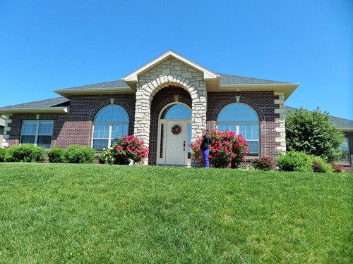 Căn nhà nằm giữa một thảm cỏ xanh mát.