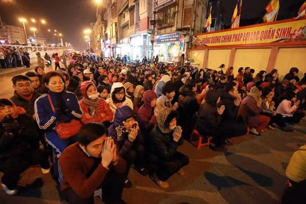 Dòng người ngồi ngoài đường làm lễ dâng sao giải hạn tại chùa Phúc Khánh. (Ảnh: Vietnamnet)