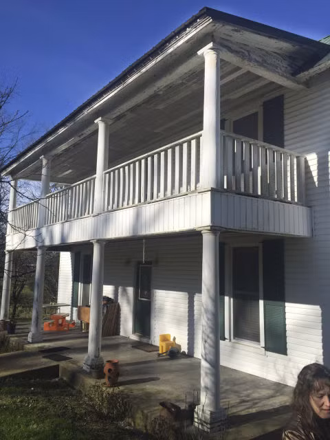 Và để tối đa hóa chỗ ngồi trên hiên nhà đôi, cô đã lắp hai cặp ghế dây văng đối diện nhau, bốn ghế bập bênh, gối hoa, lắp thêm cánh cửa bằng gỗ gụ và trồng một vài chậu cây bụi.