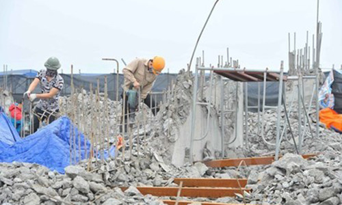 Công nhân tiến hành khoan, phá dỡ phần công trình xây dựng trái phép ở toà nhà số 8B Lê Trưc, Hà Nội, sáng 6/3. (Ảnh: Minh Đức/TTXVN)