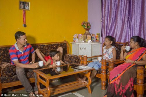 Aditya biểu diễn uốn dẻo khi ngồi uống nước cùng các thành viên khác trong gia đình cậu.