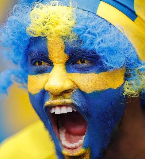 Người đàn ông Thụy Điển sơn hình quốc kỳ lên mặt, hô to khẩu hiệu chiến thắng tại sân Stade de France. Ảnh: AP