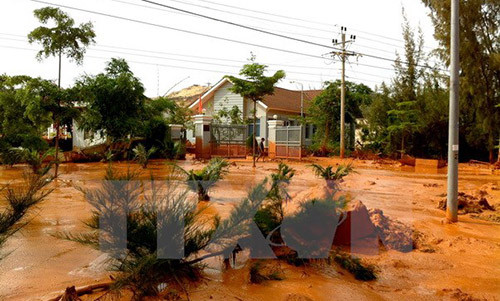 Hồ chứa nước thải khai thác titan của Công ty Bình Thuận bị vỡ hồi tháng 11/2013 khiến nước bùn đỏ chảy tràn cả vào các hộ dân. (Ảnh Nguyễn Thanh/TTXVN)