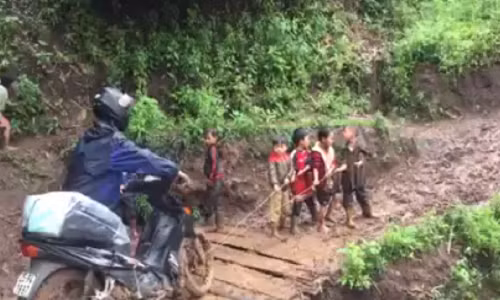 Hoc sinh lop 1 keo xe cho thay qua doan duong kho