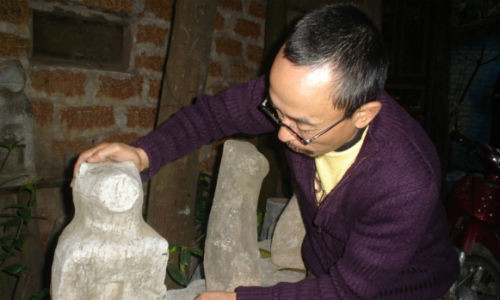 Họa sĩ Nguyễn Mạnh Đức bên chú chó đá cổ.