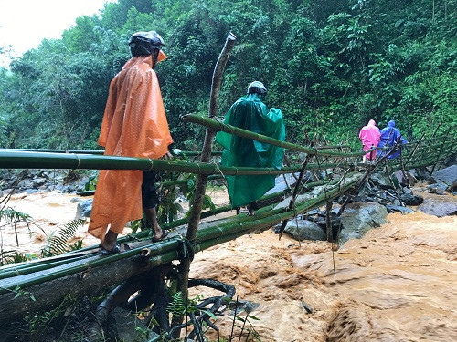 Nhiều người vẫn bất chấp nguy hiểm băng qua vị trí núi đang lở. Ảnh: Công Xuân