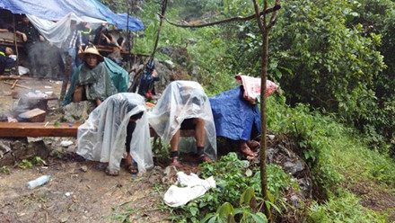 13h, cơn mưa rào ập xuống. Mọi hoạt động cứu hộ phải tạm dừng. Người nhà nạn nhân nhẫn nại trú trong các tấm áo mưa mỏng.